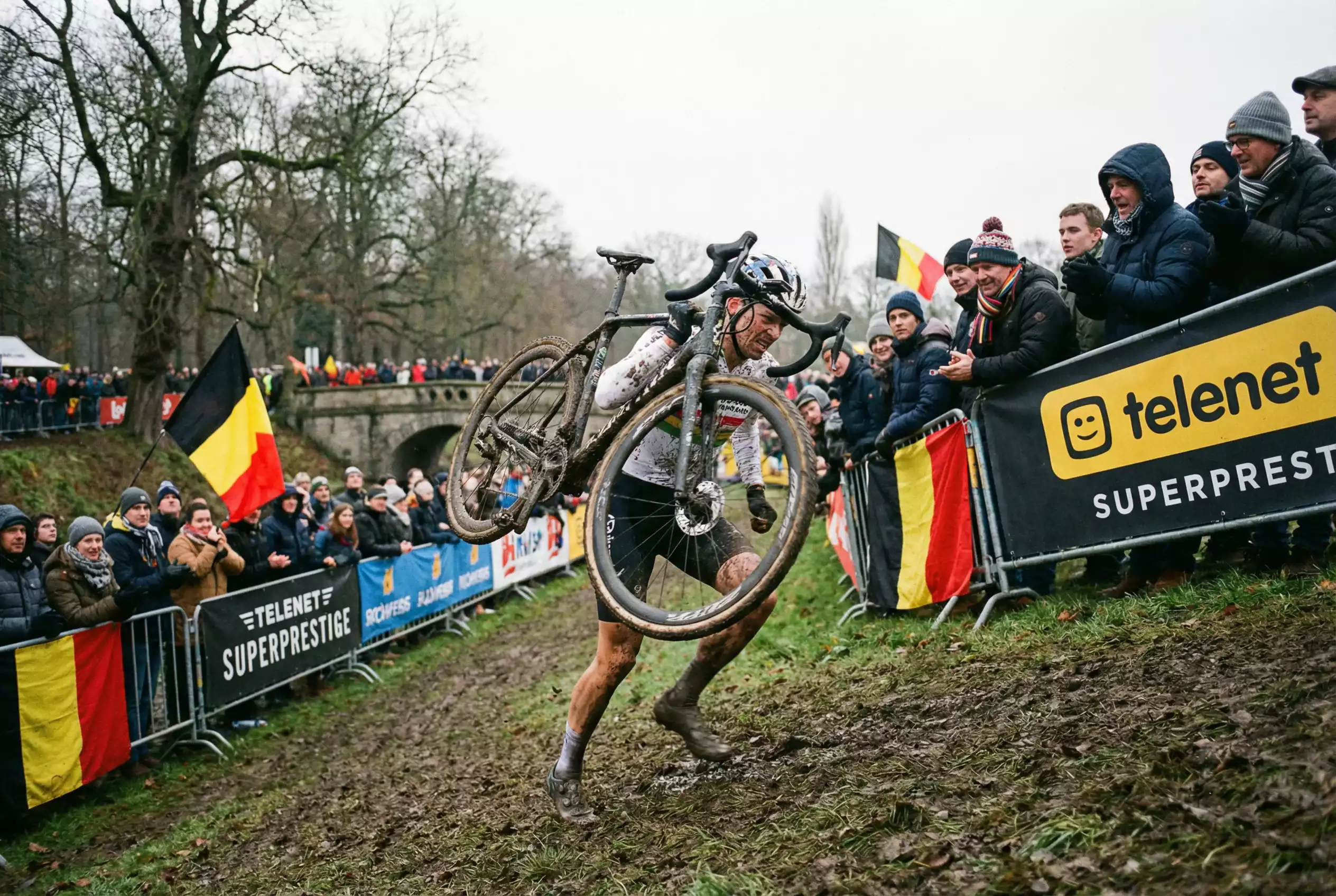 Corridore di ciclocross che affronta un percorso fangoso con la bicicletta in spalla