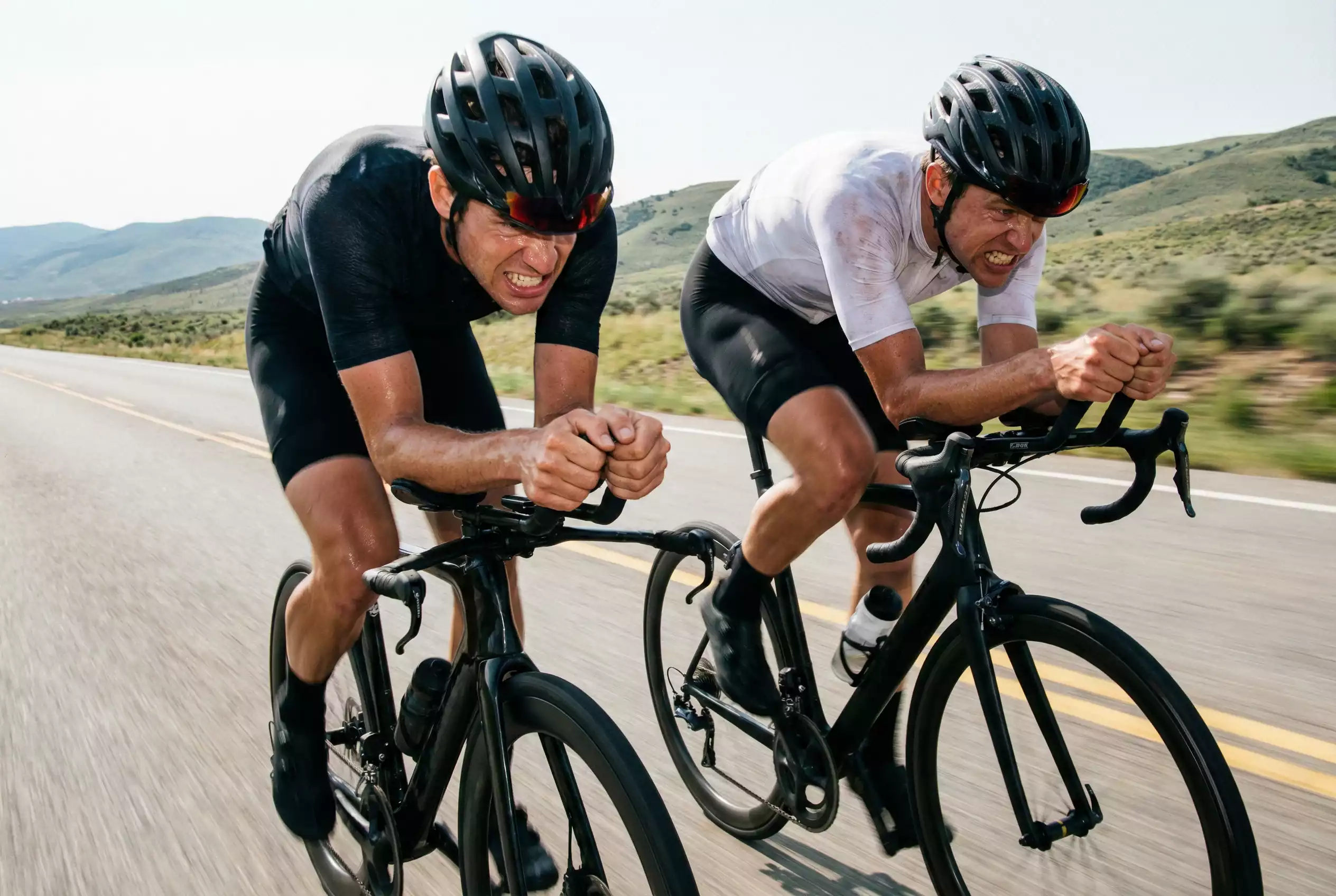 Due ciclisti professionisti fianco a fianco in un duello ravvicinato durante una corsa su strada